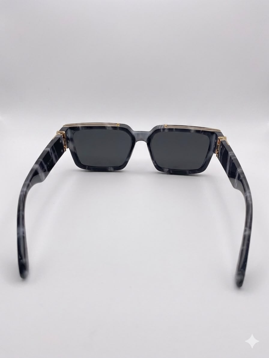Gafas de sol rectangulares con acabado de mármol y detalles dorados.
