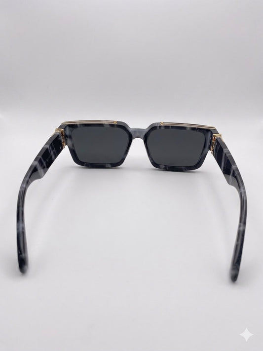 Gafas de sol rectangulares con acabado de mármol y detalles dorados.